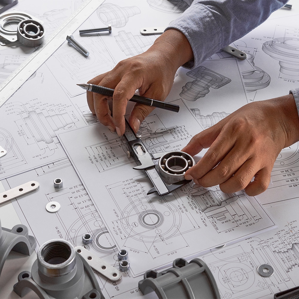 person looking over surface engineering prints