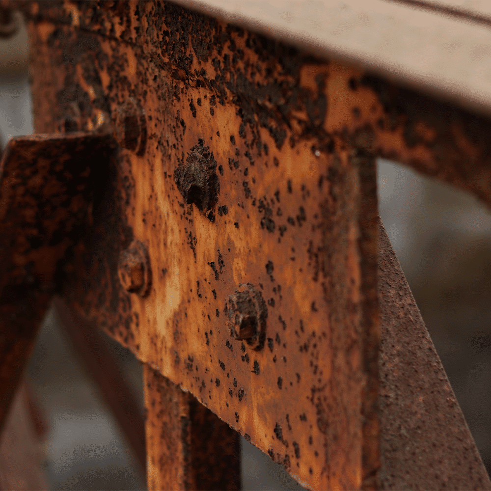 pitting corrosion on metal beam bracket of saltwater bridge