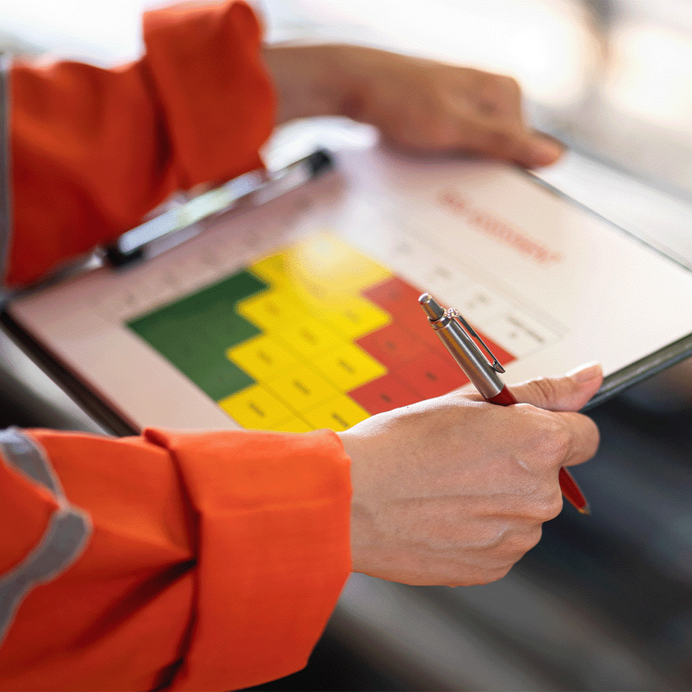 An Inspector holds a clipboard in an industrial setting, preparing to audit management systems in accordance with ISO 19011 requirements.