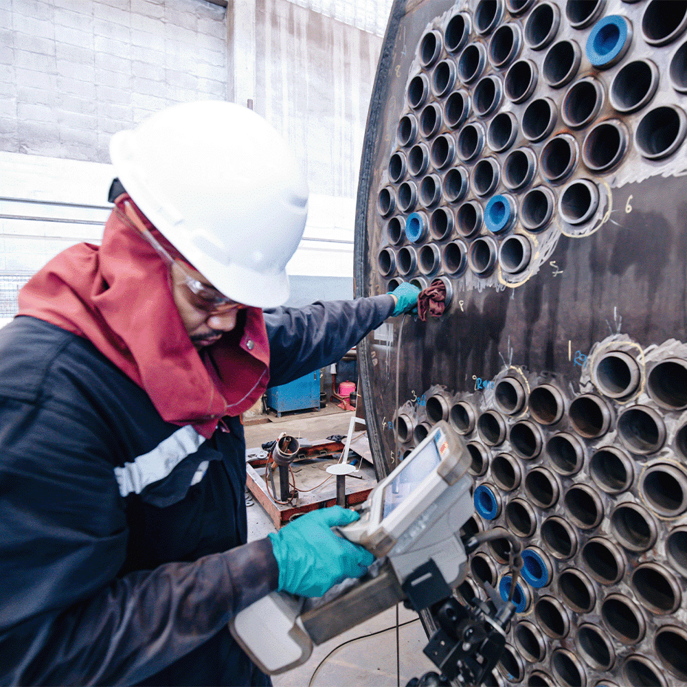 Inspector performing eddy current testing on heat exchanger tubes for pitting corrosion