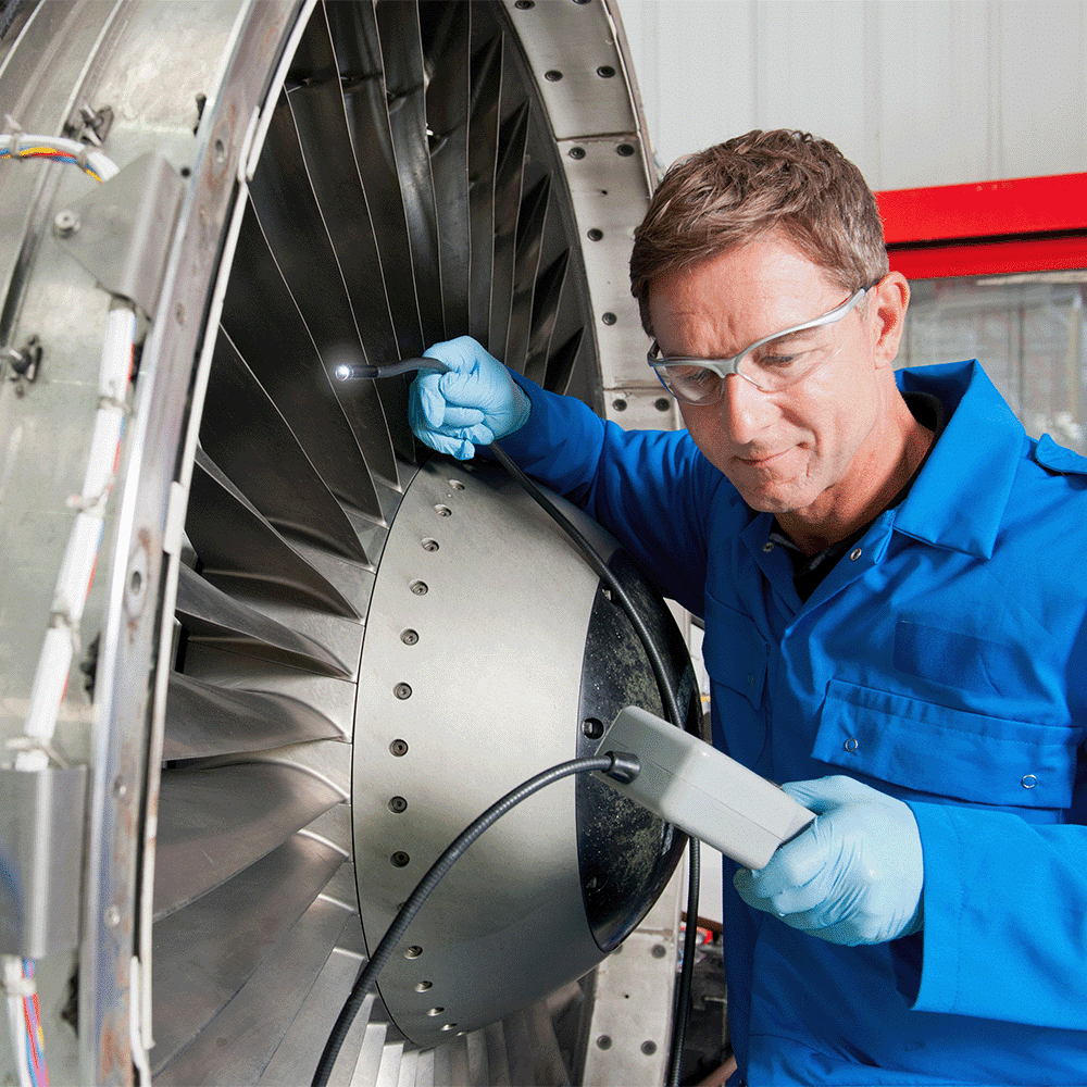 nadcap certified facility technician inspecting inside of jet engine