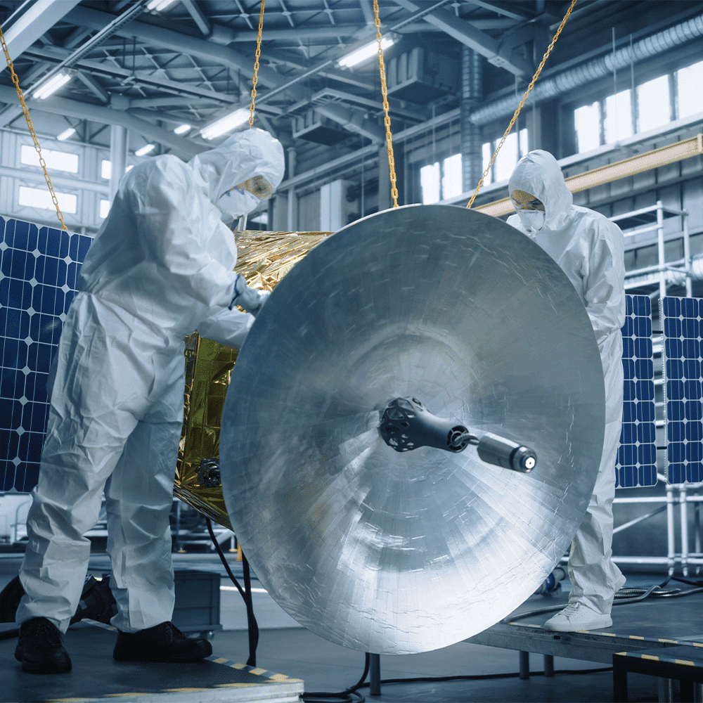 Two engineers inspect a satellite, ensuring compliance with AS9100D certification requirements